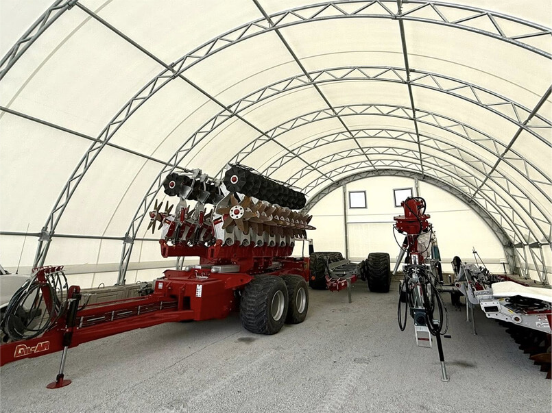 Intérieur d’un bâtiment en toile avec structure d’acier galvanisé servant à l’entreposage de machinerie agricole